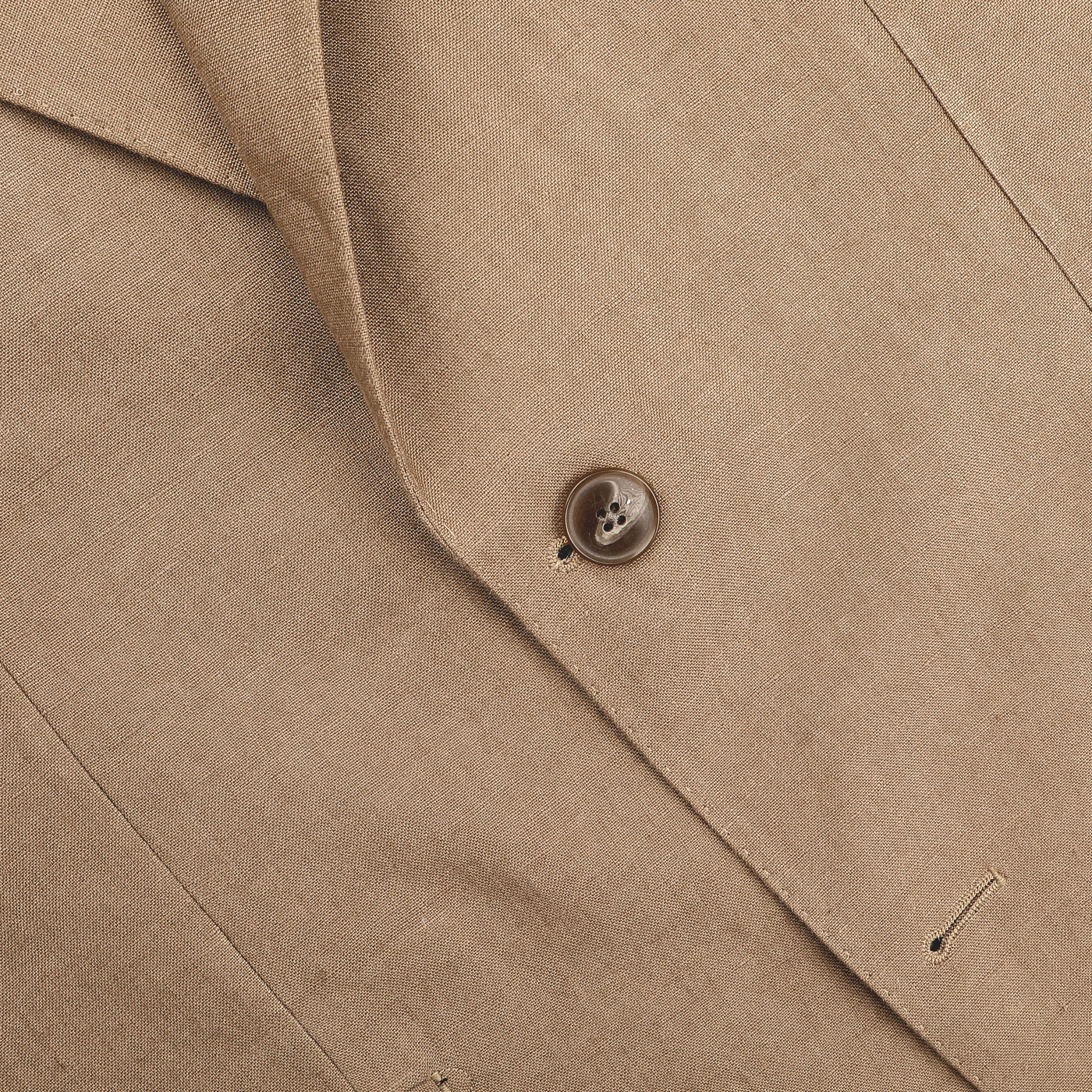 Close-up of the Taupe Beige Pure Linen Suit Jacket by Baltzar Sartorial highlighting a tan fabric and single brown button, with refined seams and buttonholes.