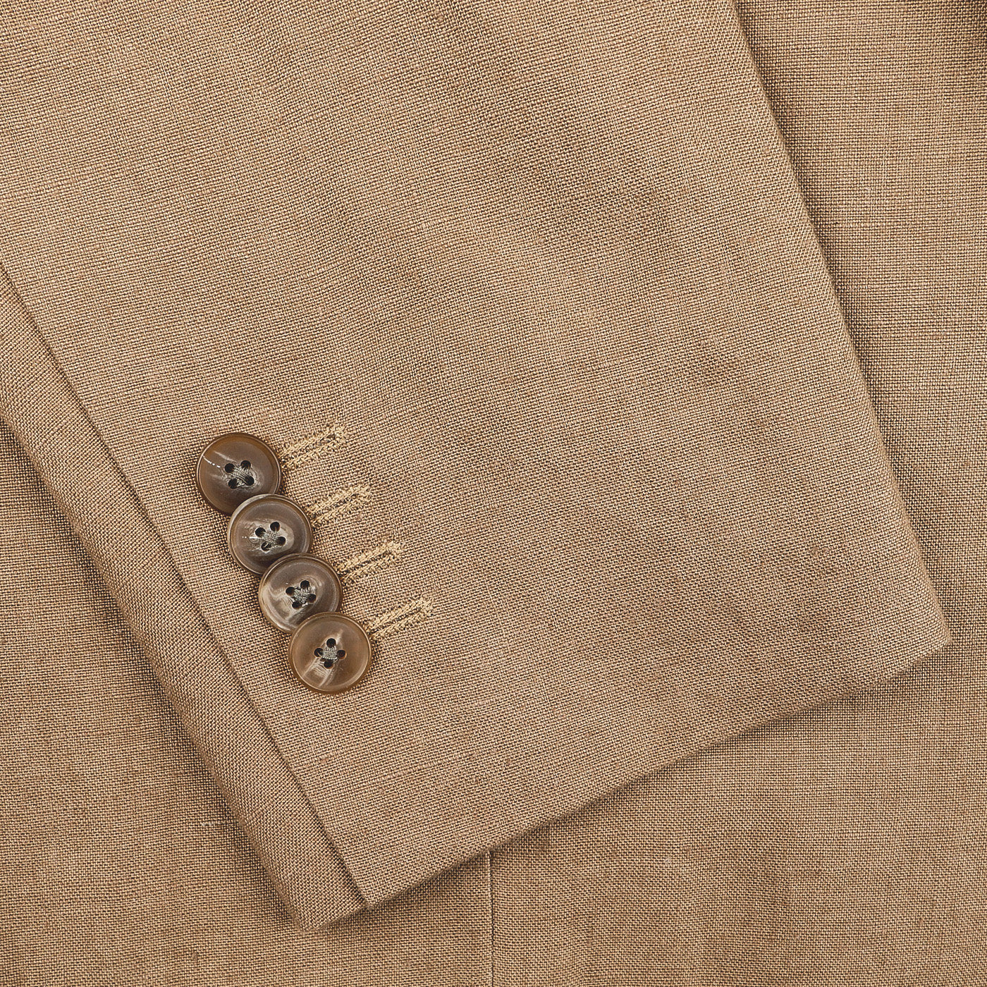 Close-up of a Taupe Beige Pure Linen Suit Jacket sleeve by Baltzar Sartorial, featuring four brown buttons stitched with beige thread.