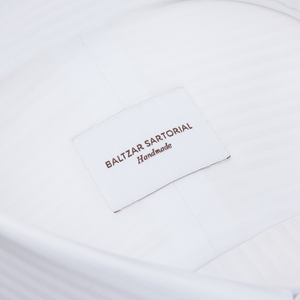 A close up of a White Striped Cotton Dinner Handmade Shirt from Baltzar Sartorial with mother-of-pearl buttons.