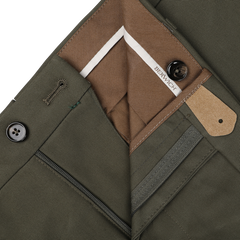 Close-up of the Army Green Cotton Twill Flat Front Trousers reveals the button closure, fly zipper, and brown interior lining with a white label that reads "Berwich." Made from durable cotton twill, these regular fit trousers offer both style and comfort.