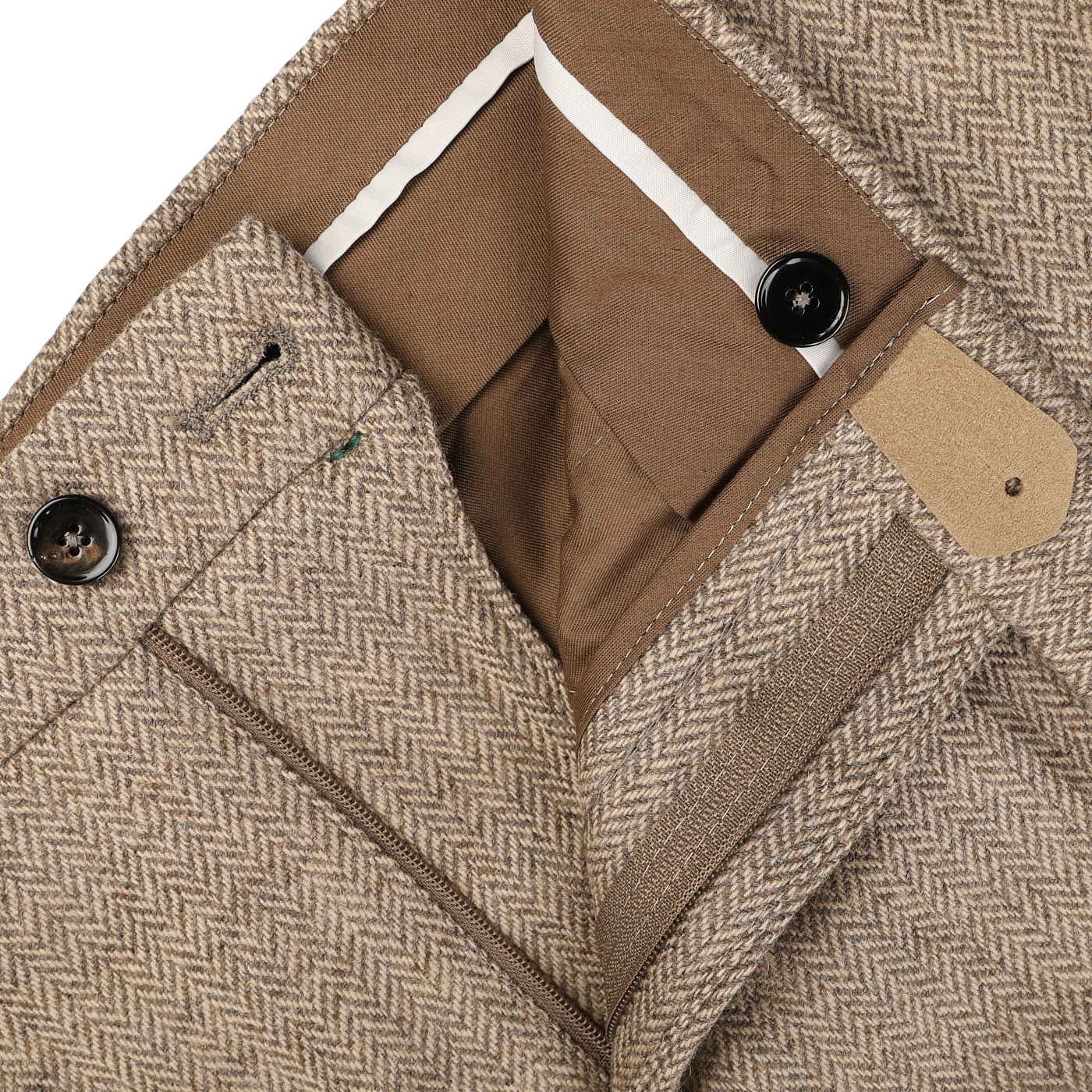 A close-up of Berwich's Beige Herringbone Wool Tweed Trousers highlights the taupe beige fabric and herringbone pattern, complete with a button and zip closure, showcasing the pure wool interior waistband and pockets.