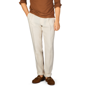 A man in a brown shirt and Berwich cream linen twill drawstring trousers.
