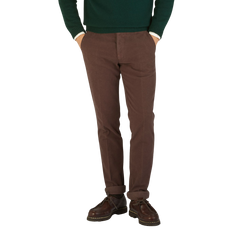 A man wearing Berwich Dark Brown Cotton Moleskin Chinos and a green sweater.