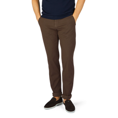 A man wearing Berwich dark brown cotton stretch chinos and a blue shirt.