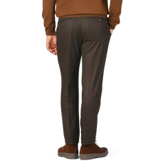 A person wearing Berwich Dark Brown Wool Flannel Flat Front Trousers, brown shoes, and a brown top, crafted from pure wool flannel, is shown from the back and isolated on a plain background.