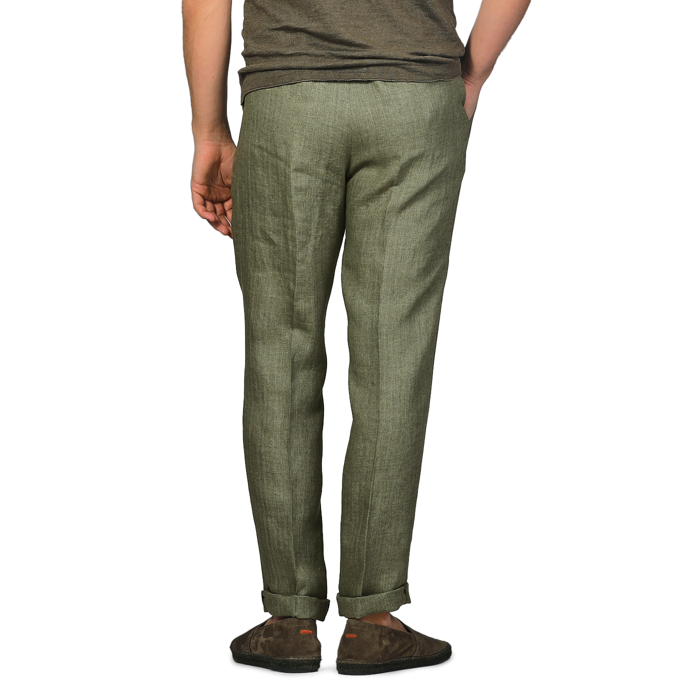 A person wearing Berwich's Green Linen Herringbone Drawstring Trousers in a slim fit and brown shoes stands with their back to the camera.