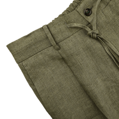 Close-up of Berwich's Green Linen Herringbone Drawstring Trousers, featuring an olive green herringbone pattern and crafted with pure linen.