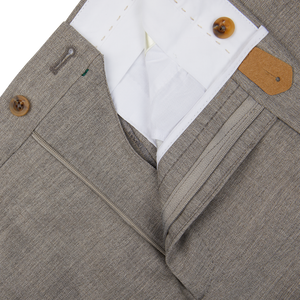 A close-up of Grey Beige Wool Fresco Flat Front Trousers made from high-twist wool by Berwich with a white button.
