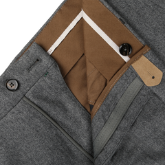 Close-up of a pair of Berwich Grey Wool Flannel Flat Front Trousers in Vulcano fit with the zipper and button fly partially open, revealing brown and white inner lining and pocket details, crafted from luxurious wool flannel.