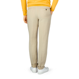 A person wearing Berwich light beige linen blend flat front trousers and a yellow shirt.