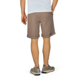 Man standing in Light Brown Cotton Blend Pleated Shorts and white t-shirt with hands partially in pockets, wearing grey sneakers by Berwich.