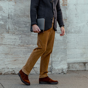 A man wearing a black jacket and the Berwich Light Brown Cotton Corduroy Flat Front Trousers.