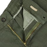 Close-up of a Berwich militare green washed linen drawstring shorts with a zipper and button detail.