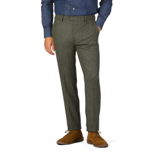 Man wearing a blue long-sleeve shirt and brown shoes, standing against a plain background in Berwich Moss Green Herringbone Wool Tweed Trousers.