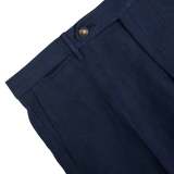 Close-up of Berwich navy blue melange linen flat front trousers with a buttoned waistband and a front pocket detail.