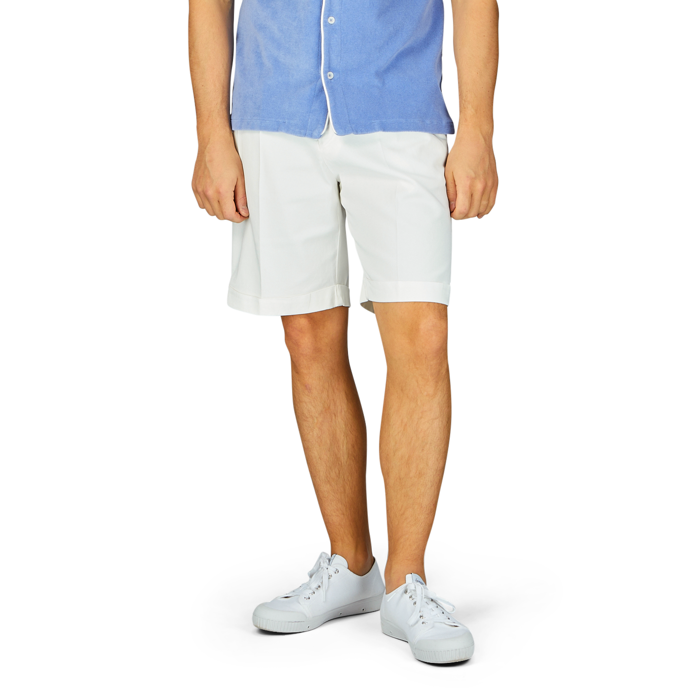 Man standing in blue shirt, Off-White Cotton Blend Pleated Shorts, and white sneakers.