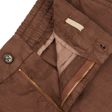 Close-up of a Berwich terra brown washed linen drawstring shorts with a zipper, button, and pocket details on a light background.