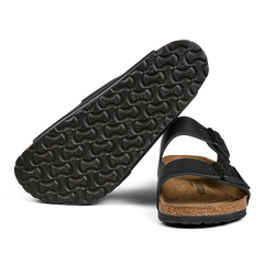 A black Birkenstock sandal with a cork footbed and a pronounced tread pattern on the sole.