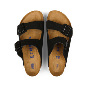 A pair of Black Suede Leather Arizona sandals by Birkenstock with buckles on a black background.
