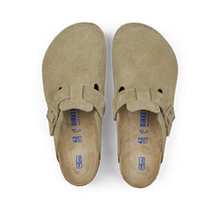 A pair of Faded Khaki Suede Leather Birkenstock Boston Slippers displayed against a black background.