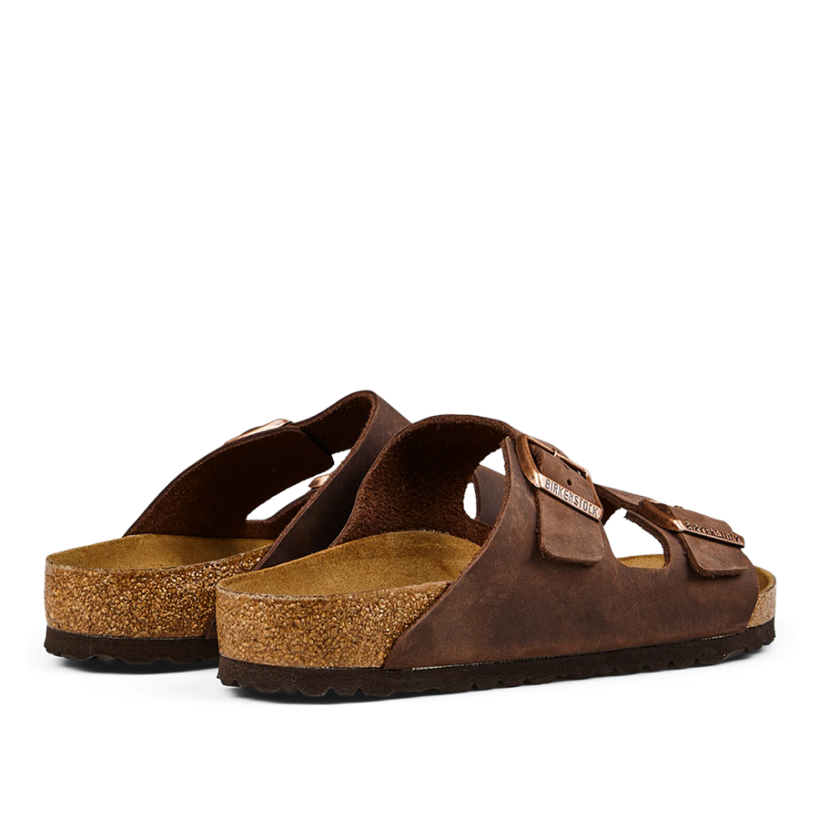 A pair of brown leather Birkenstock Arizona sandals with cork footbeds and rubber soles.