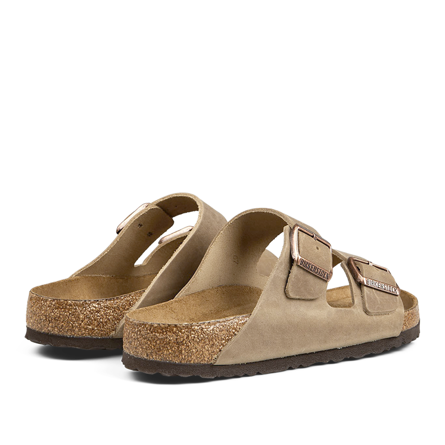 A pair of Tabacco Brown Natural Leather Arizona Sandals with cork soles and adjustable straps by Birkenstock.