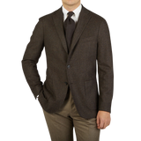 A man is posing in a Boglioli Brown Checked Lambswool K Jacket, showcasing the unstructured craftsmanship of his brown suit and tan pants, proudly made in Italy.