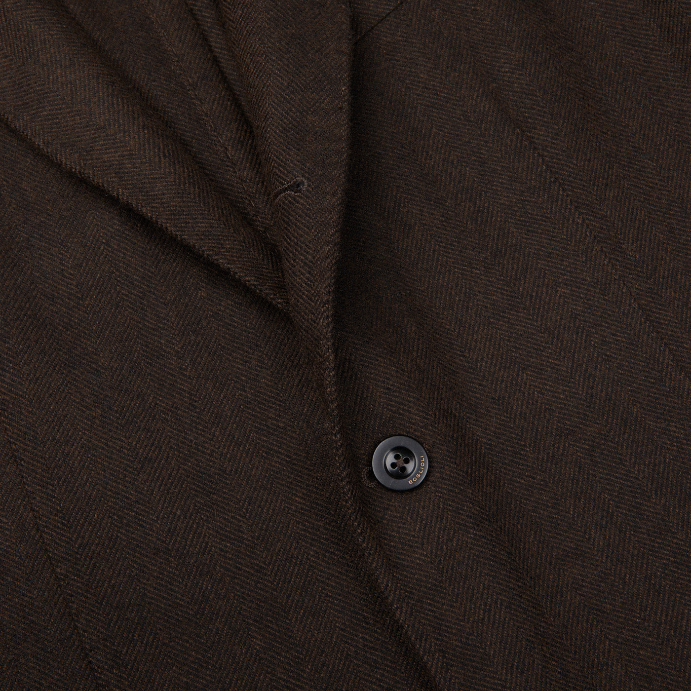 A close up of a regular fit, unstructured Boglioli brown Herringbone Wool K.Jacket with buttons showcasing meticulous craftsmanship.