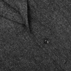 A detailed view of the Dark Grey Herringbone Wool Tweed K Jacket by Boglioli reveals a black button accentuating its unstructured craftsmanship.