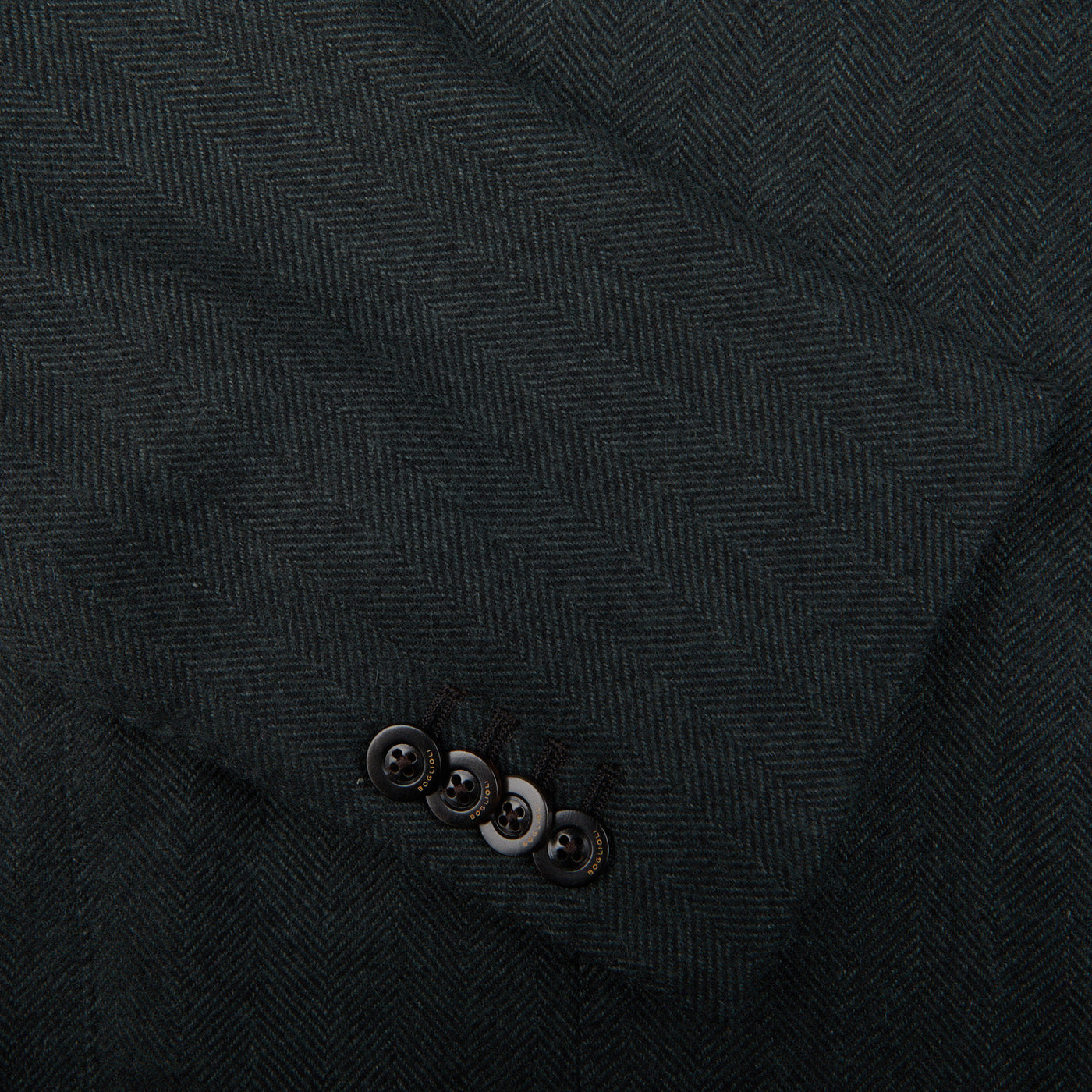 A close up of a dark green Boglioli Green Herringbone Wool K Jacket suit with unstructured craftsmanship.