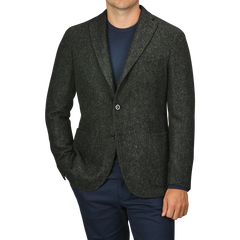 A person wearing a Green Herringbone Wool Tweed K Jacket by Boglioli over a navy shirt and navy pants, with their hands in their pockets.