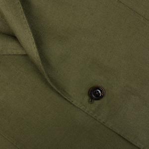 Close-up view of a black button on Boglioli's Green Washed Irish Linen K Jacket fabric.