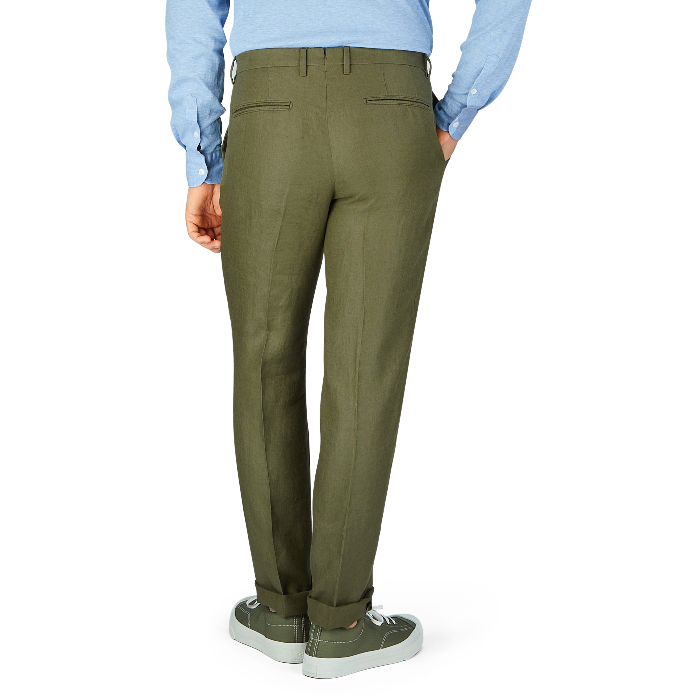 A person standing in Boglioli green washed Irish linen trousers and gray sneakers paired with a light blue shirt.