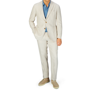 A person wearing a Boglioli Light Beige Washed Irish Linen K Jacket with a blue shirt and matching beige shoes.