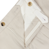 Close-up of light beige Boglioli Irish linen trousers with zipper and button details.