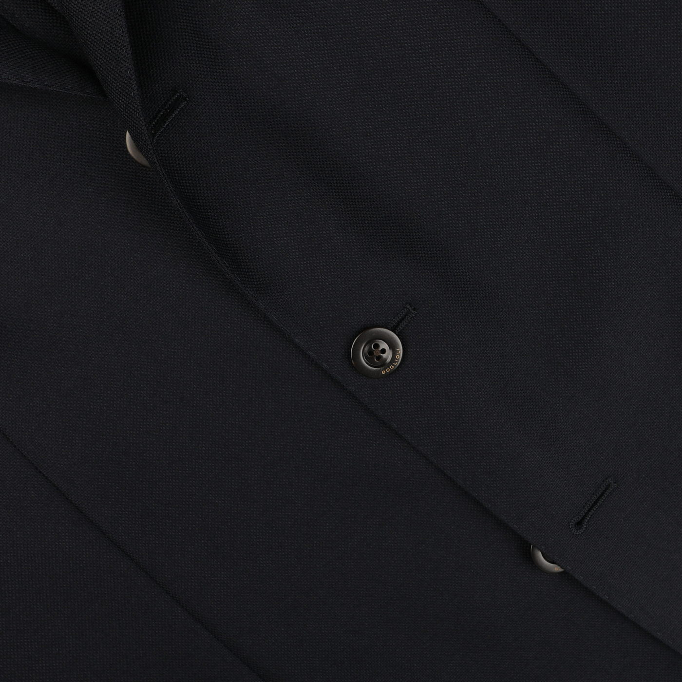 Close-up of a navy blue Boglioli K Jacket suit jacket made from virgin wool, showcasing two buttons, buttonholes, and part of the lapel.