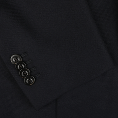 Close-up image of a navy blue jacket sleeve crafted from virgin wool by Boglioli, showcasing four black buttons neatly arranged in a row near the cuff.