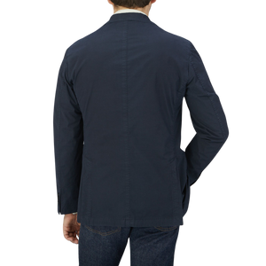 Man seen from behind wearing a Dark Blue Washed Cotton K Jacket by Boglioli with unstructured craftsmanship from Italy and denim jeans.
