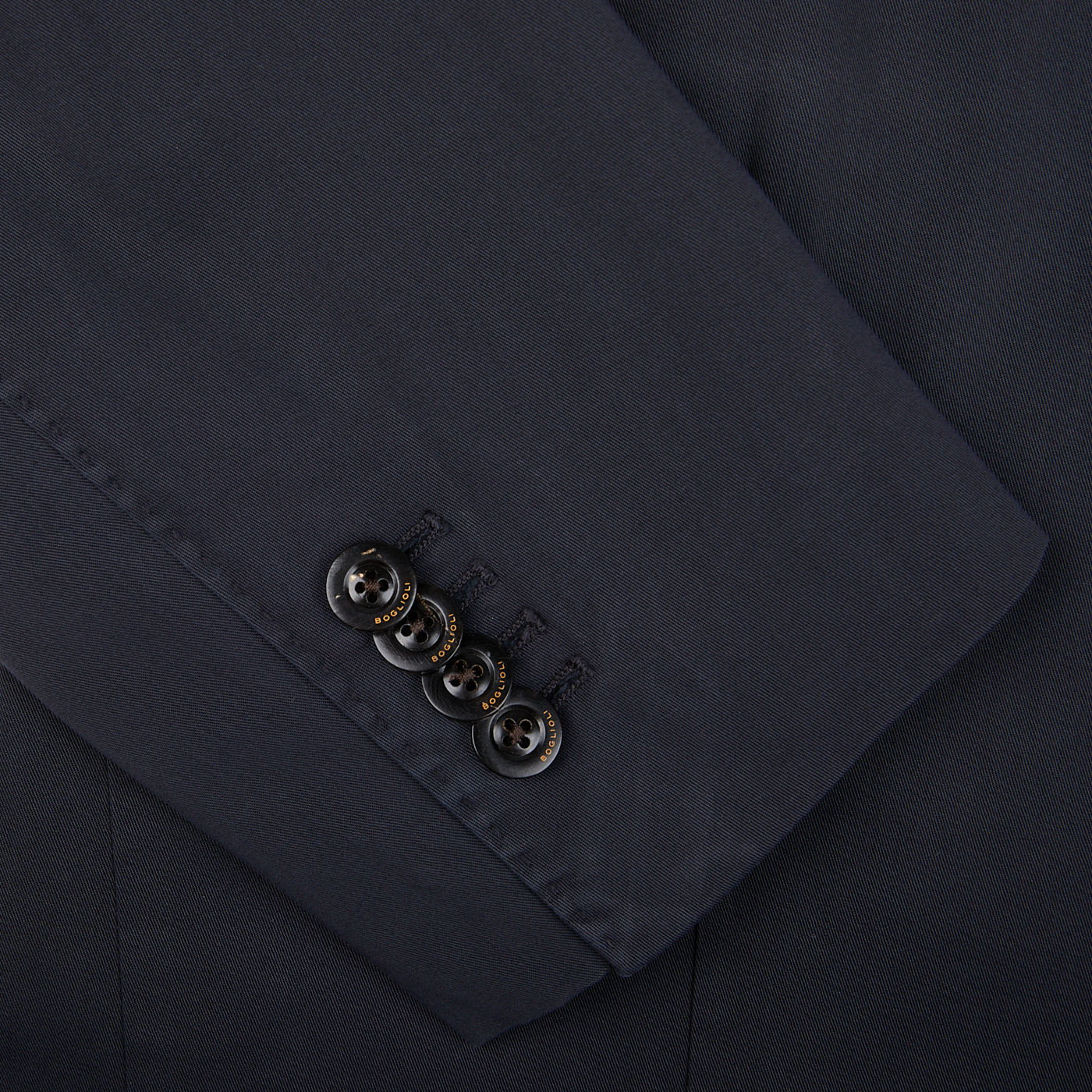 Close-up of an unstructured Boglioli navy blue suit sleeve with four buttons, indicative of K.Jacket's Italian craftsmanship.
