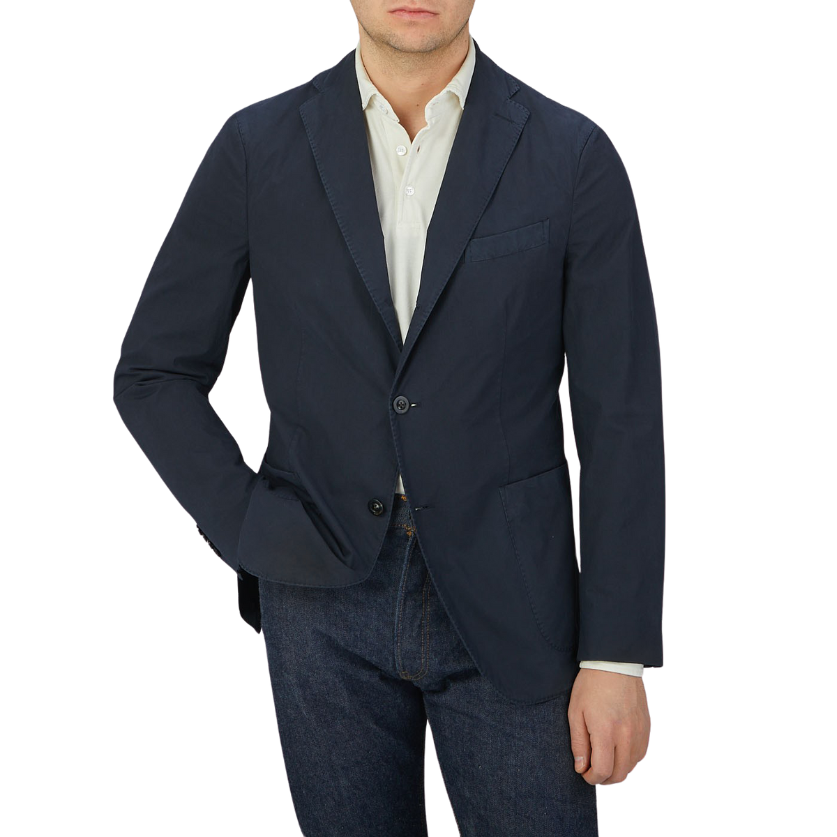 Man wearing an Italian Boglioli Dark Blue Washed Cotton K Jacket with unstructured craftsmanship, cream shirt, and blue jeans.