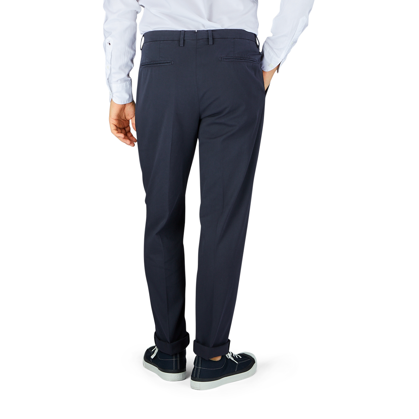 A man's legs in Boglioli navy blue washed cotton pleated trousers and hands in the back.