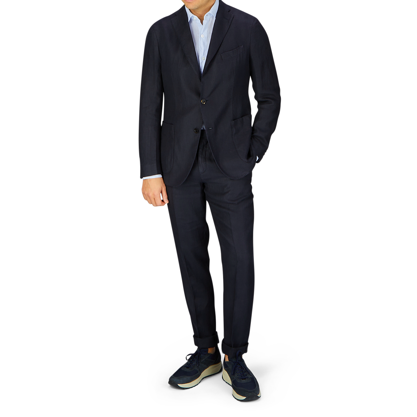 Man standing in a dark Boglioli Navy Blue Washed Irish Linen K Jacket suit paired with casual sneakers on a white background.
