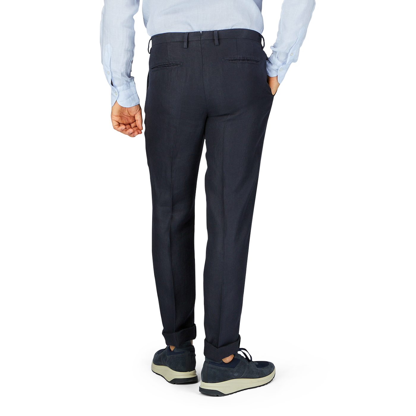 Man standing in profile wearing Boglioli Navy Blue Washed Irish Linen Trousers and sneakers.