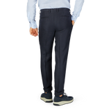 Man standing in profile wearing Boglioli Navy Blue Washed Irish Linen Trousers and sneakers.