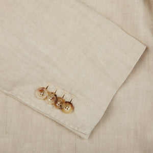 A close up of a Boglioli Sand Beige Washed Linen Unstructured Suit with buttons made from linen fabric.