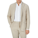 A gentleman dressed in a Boglioli Sand Beige Washed Linen Unstructured Suit and white shirt.