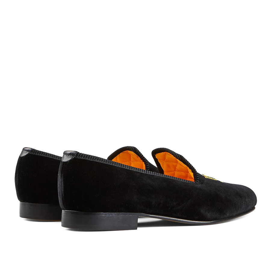 A pair of Black Velvet Bowhill Elliott Slippers with orange lining.