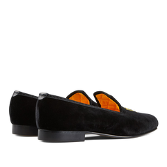 A pair of Black Velvet Bowhill Elliott Slippers with orange lining.