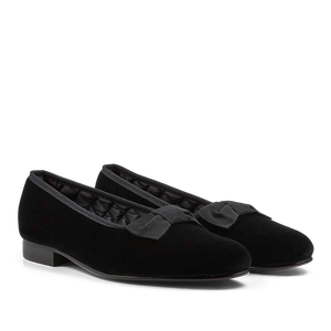 A pair of Black Velvet Bow Opera Pumps by Bowhill Elliott women's formal shoes with bows on a black background.