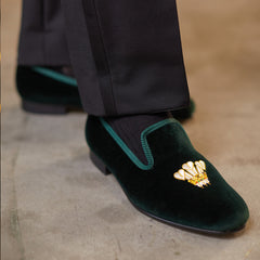 A man donning luxurious Green Velvet Feathers Albert Slippers by Bowhill Elliott, delicately handmade.